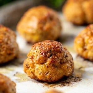 Baked Chicken Meatballs on parchment paper on a baking sheet.