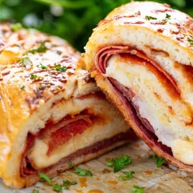 Stromboli cut in half to show cross-section of meat and cheese.