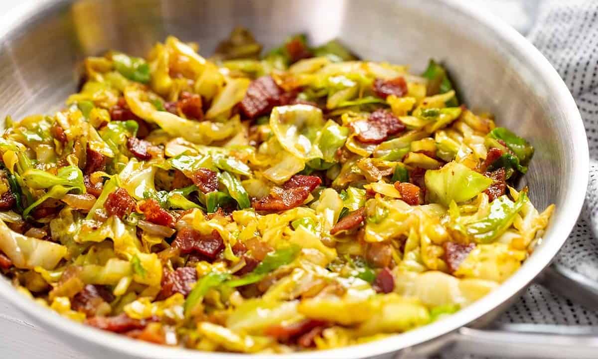 Fried Cabbage and bacon mixed together in a stainless steel bowl.