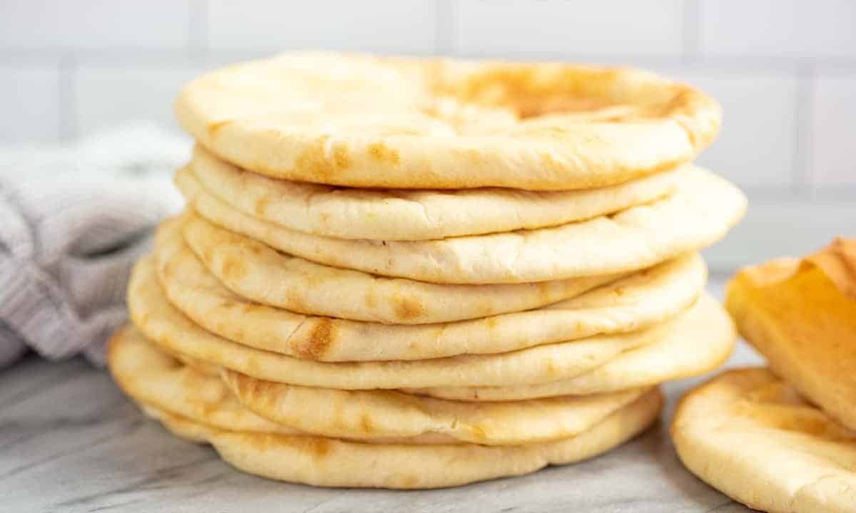 Stack of pita bread on a marble countertop.
