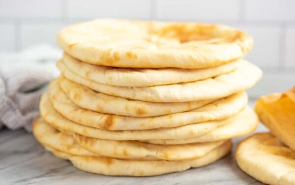 Stack of pita bread on a marble countertop.