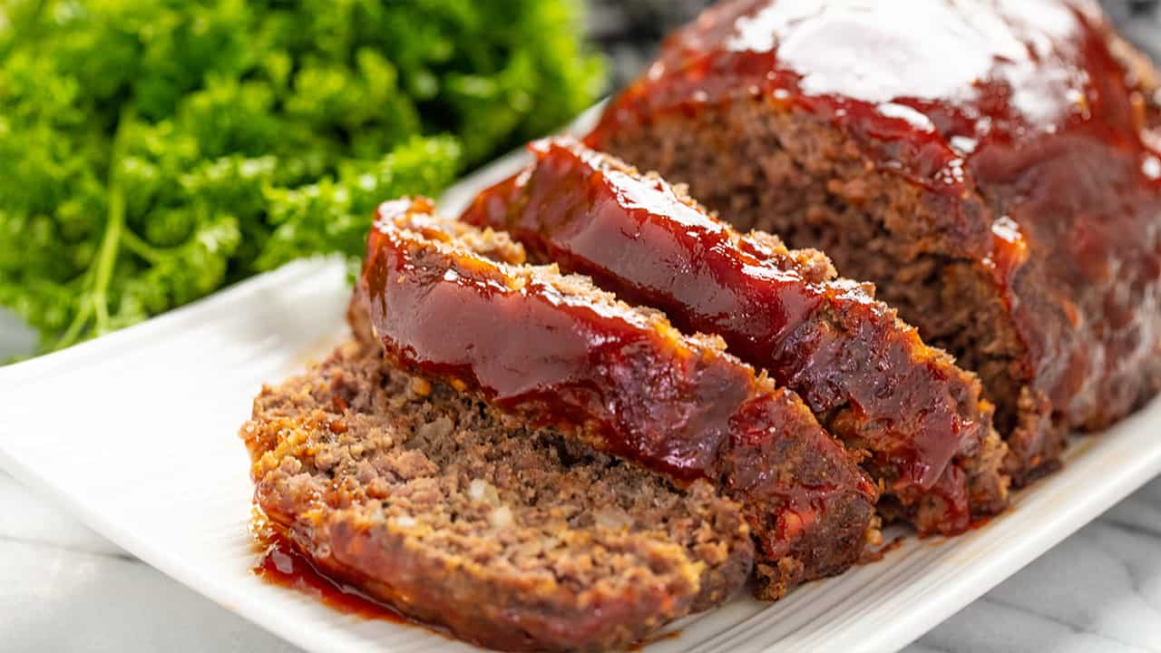 Meatloaf sliced on a white platter.