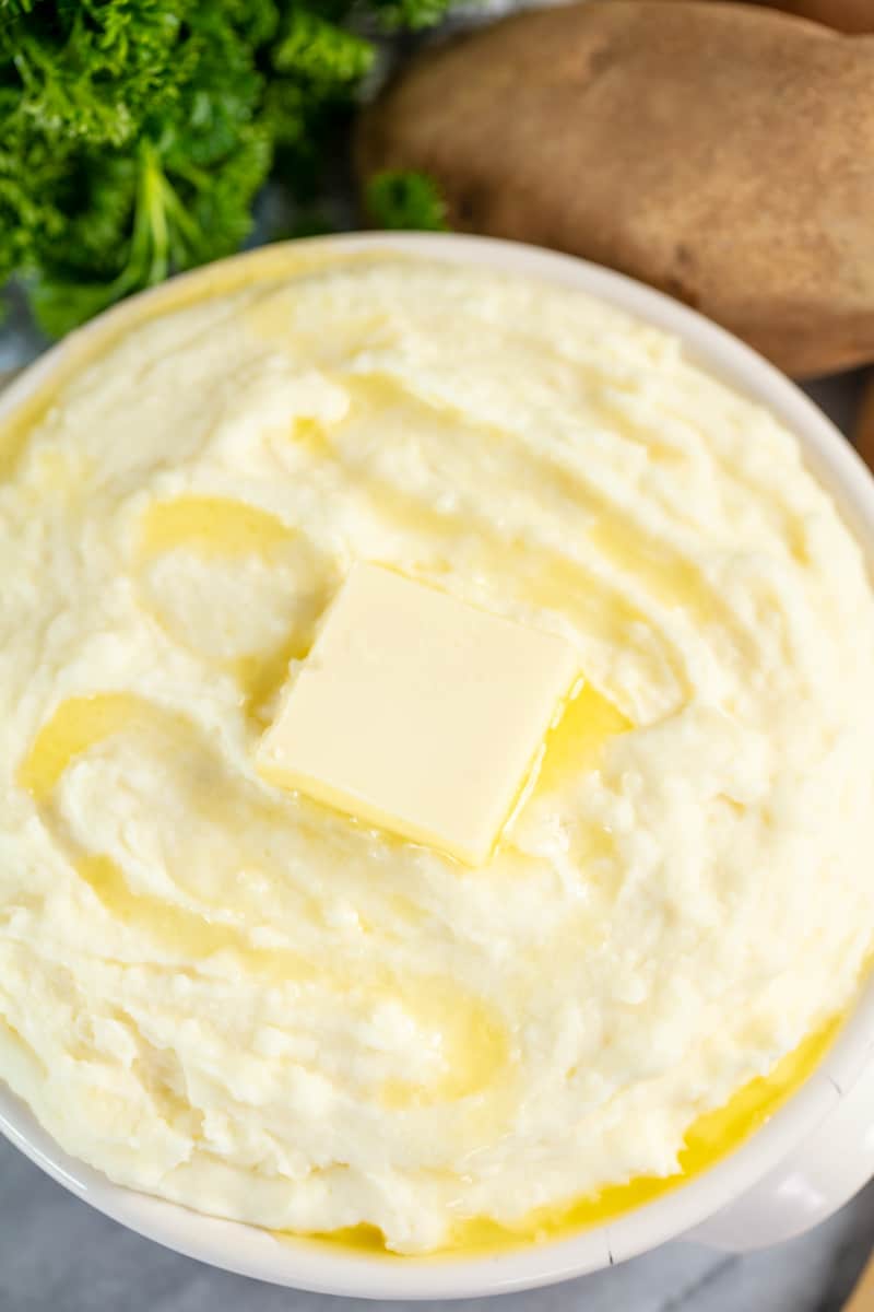 Creamiest Mashed Potatoes in a serving bowl, topped with with melting butter