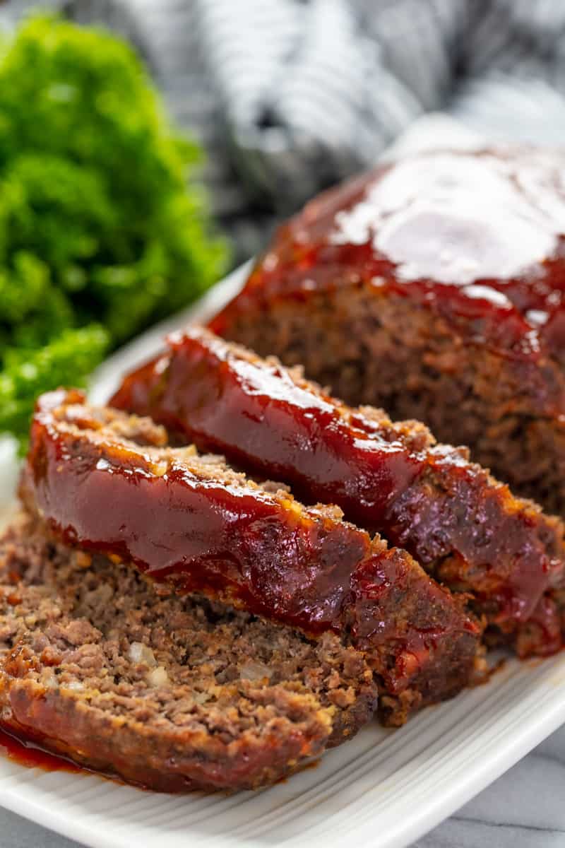 Meatloaf sliced and on a white plate.