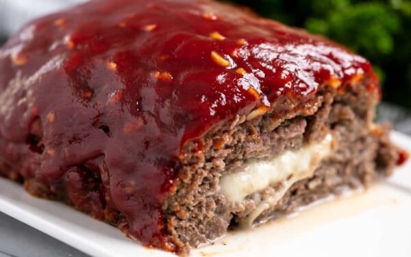 Cross-section of a loaf of Slice of Mozzarella Stuffed Meatloaf revealing the gooey mozzarella cheese inside.
