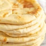 Stack of pita bread on a marble countertop.