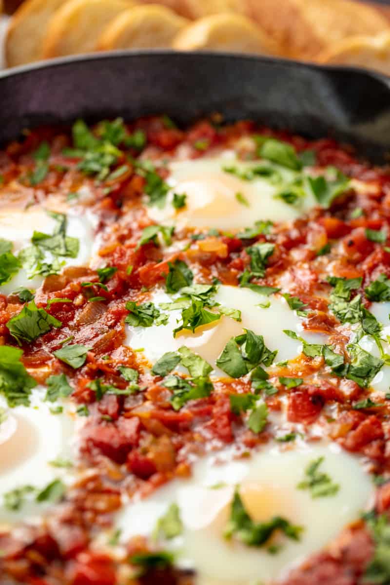 Close up Shakshuka in a cast iron skillet.