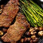 Skillet Steak with Asparagus and Mushrooms in a cast-iron skillet.