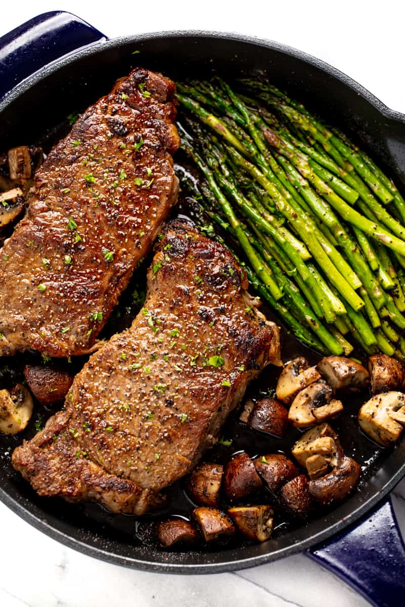 Skillet Steak with Asparagus and Mushrooms in a cast-iron skillet.