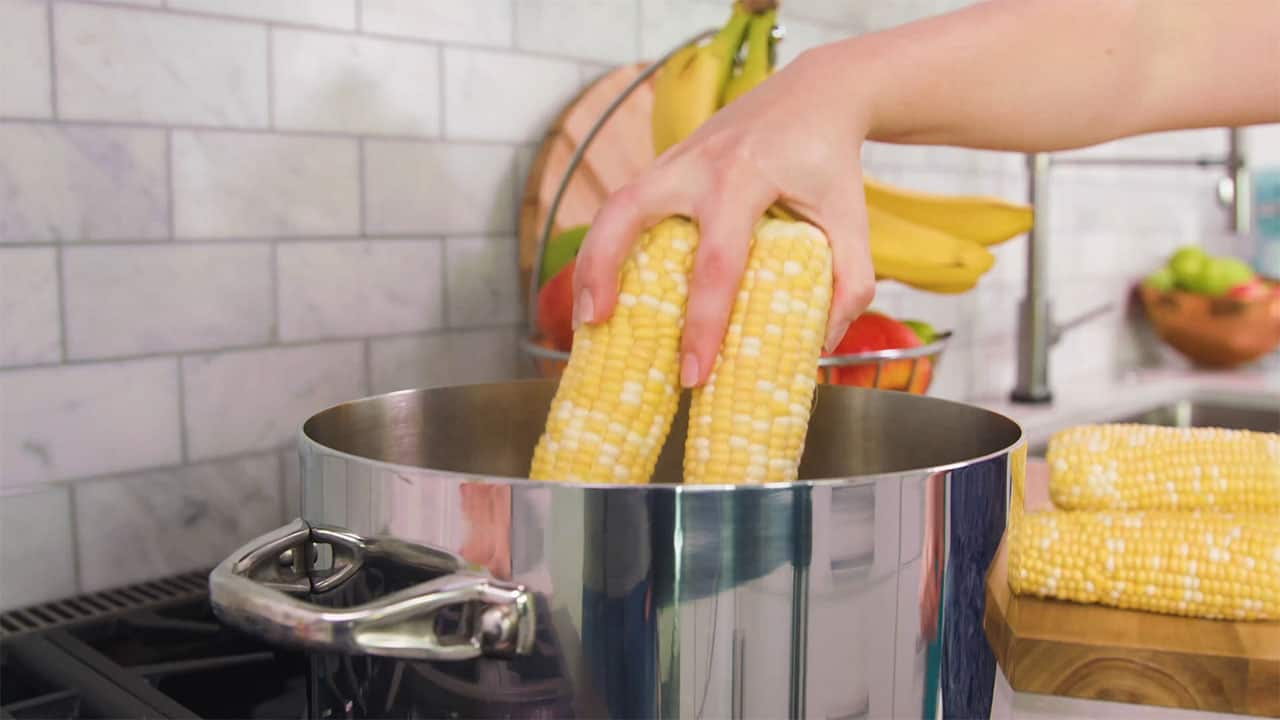 Add corn on the cob boiling water in pot on stovetop.