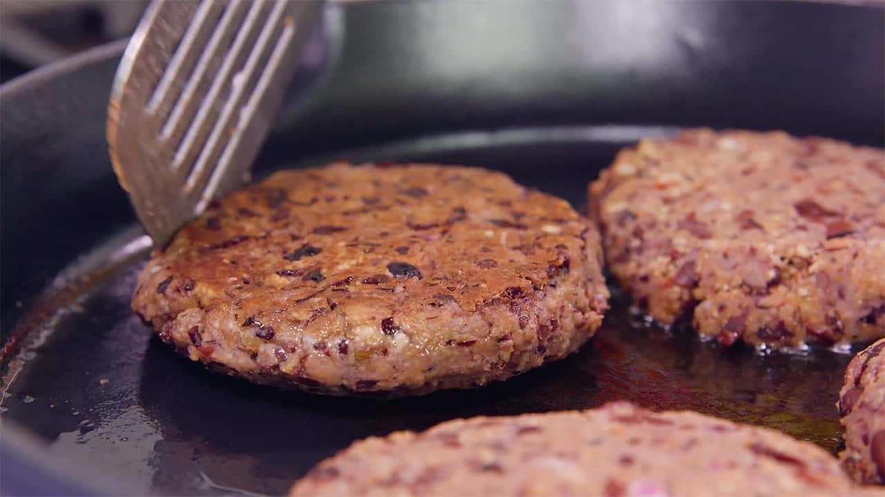 In a hot cast iron skillet, sear each side of the black bean burger patties to desired doneness using a metal spatula.