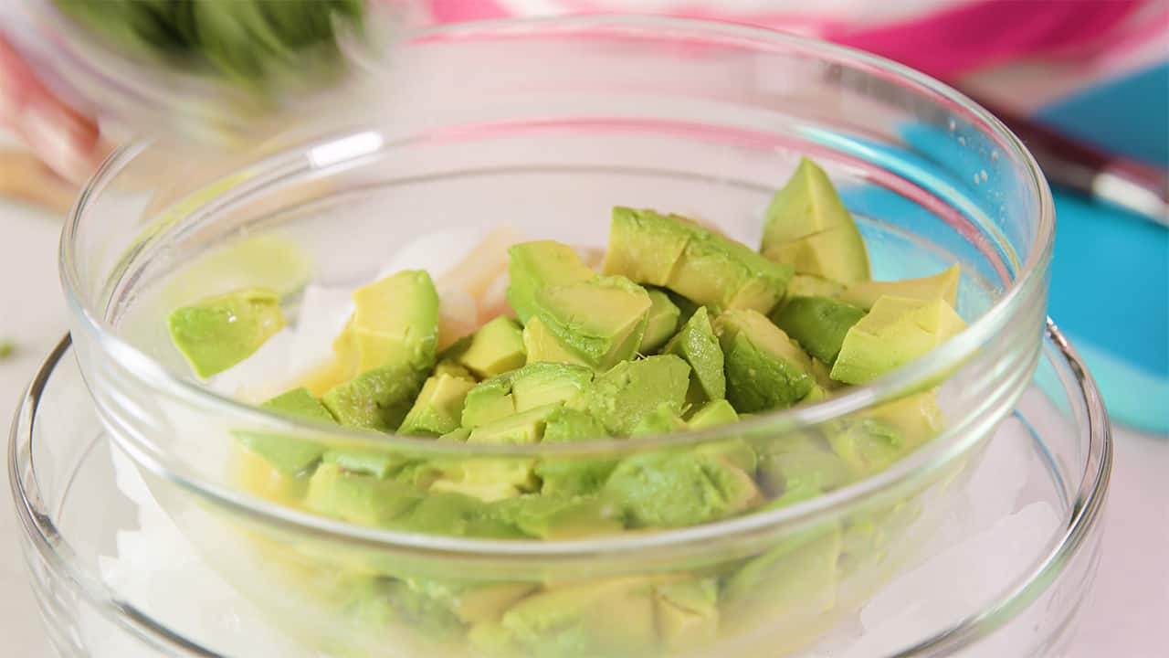 Add freshly diced avocado to mixing bowl of fish and juice mixture.