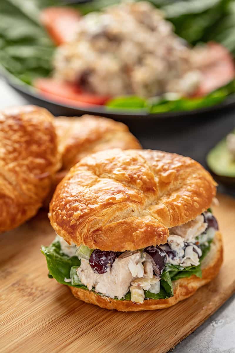 Chicken Salad in a croissant sandwich sitting on a cutting board.