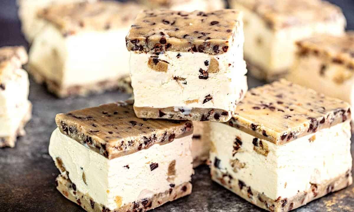 Three Cookie Dough Ice Cream Sandwiches stacked on a metallic surface.
