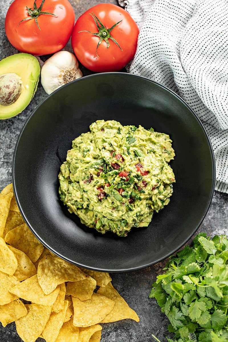 Bird's eye view of Guacamole in a black bowl.