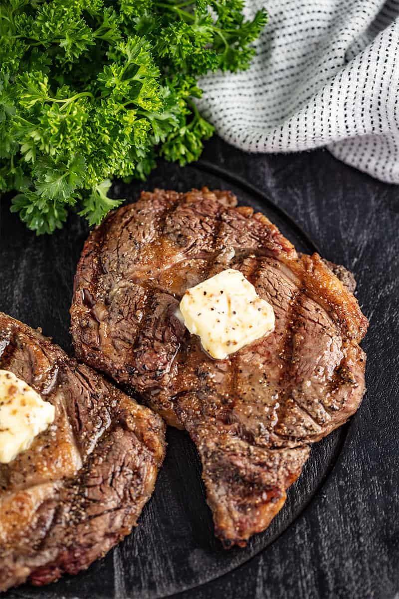 Bird's eye view of Grilled Steak with a pad of butter on it.