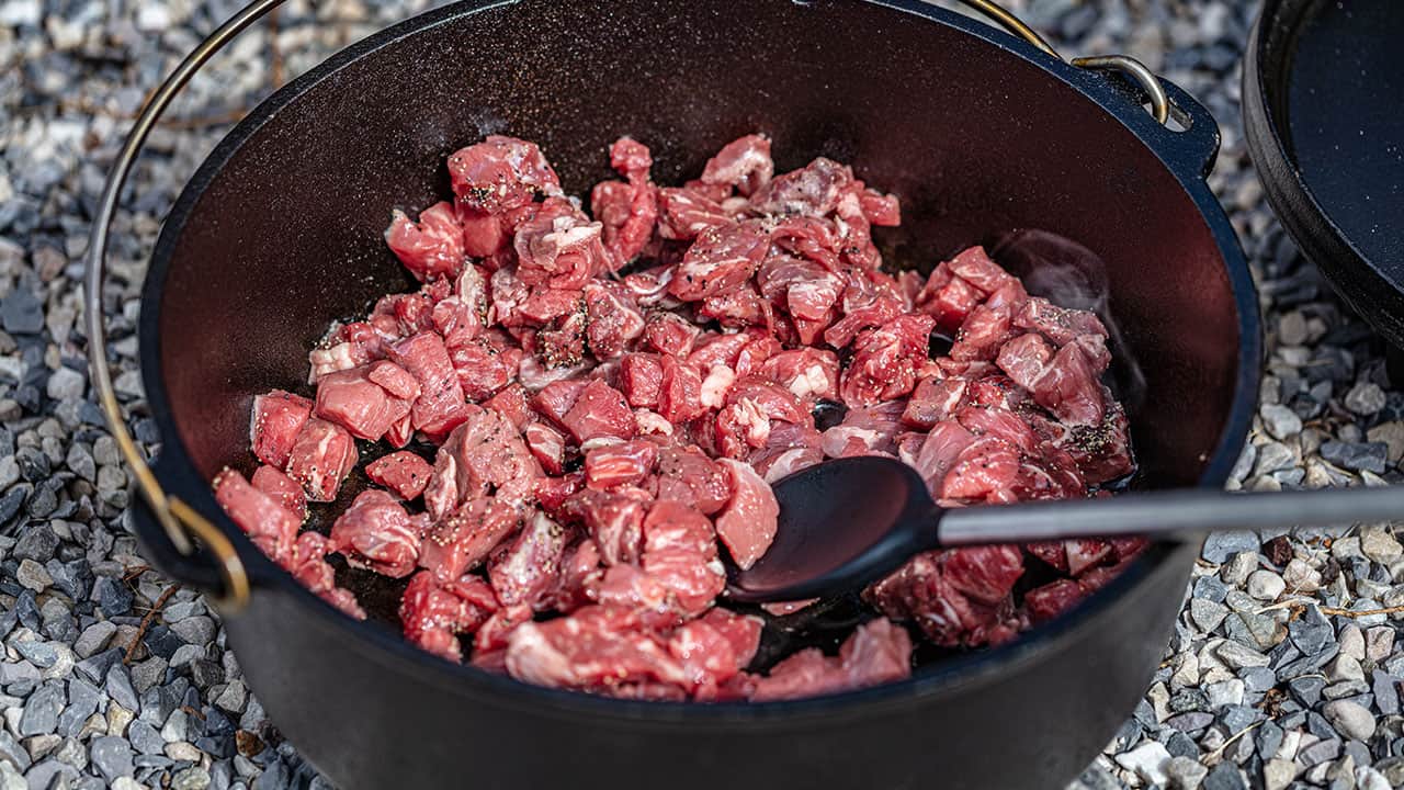 Searing chunks of beef in a cast iron dutch oven