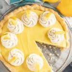 Old Fashioned Creamy Lemon Pie topped with dollops of stabilized whipped cream and lemon wedges