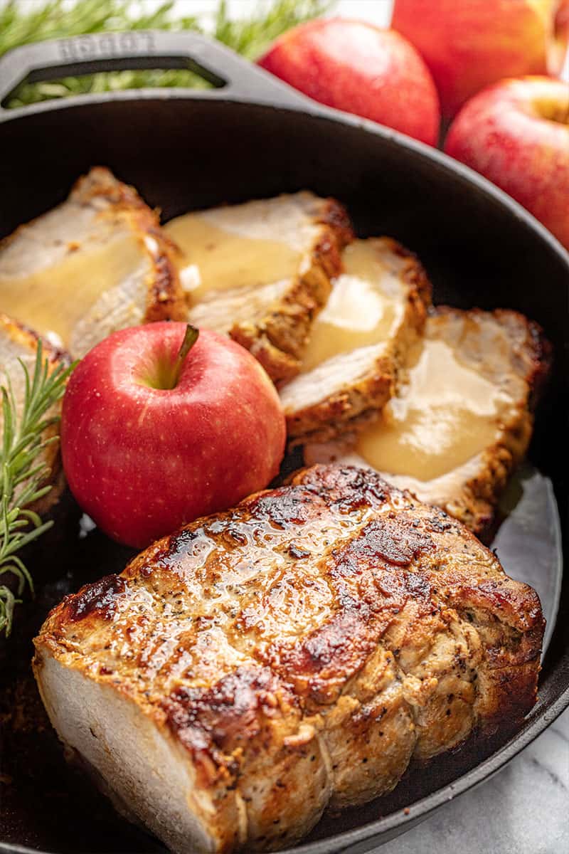 Apple Glazed Roasted Pork Loin in a skillet with an apple.