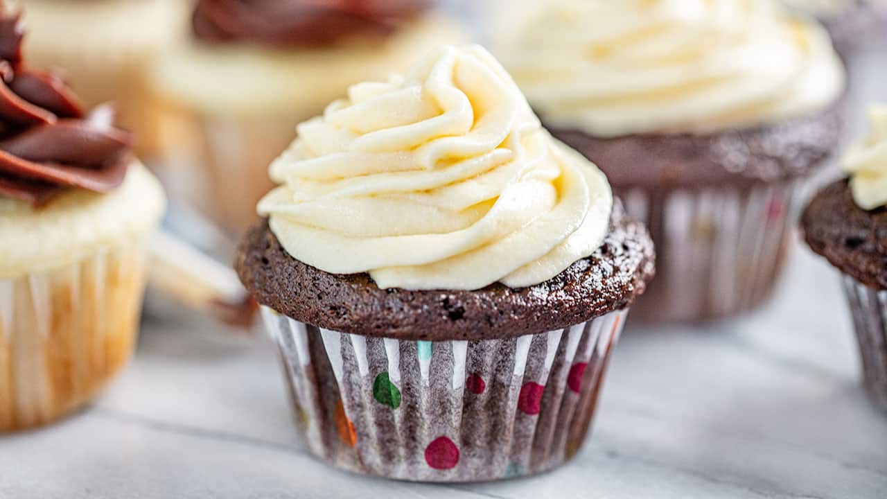 sweetened condensed milk frosting on a chocolate cupcake