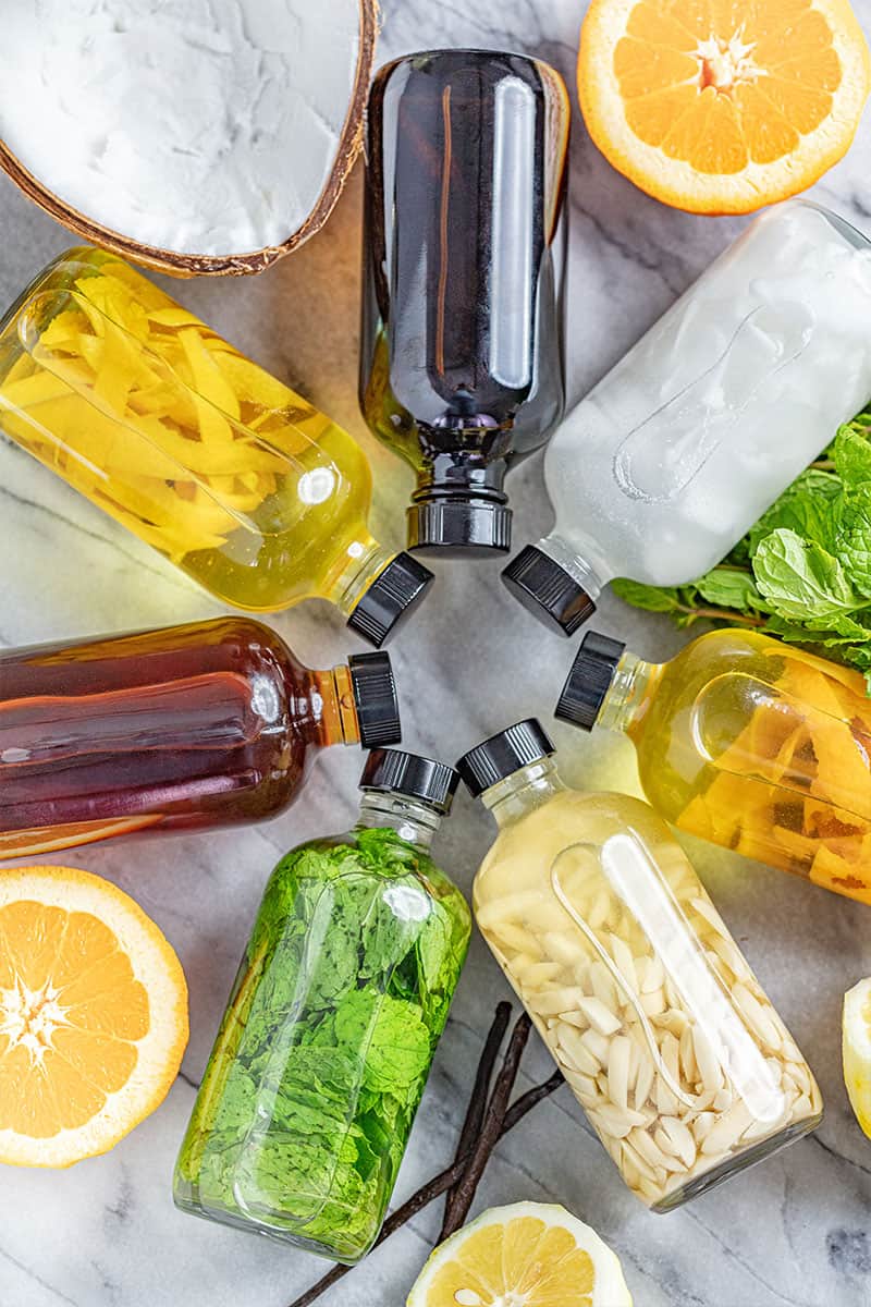 bottles of various homemade extracts laying on their sides in a circle.