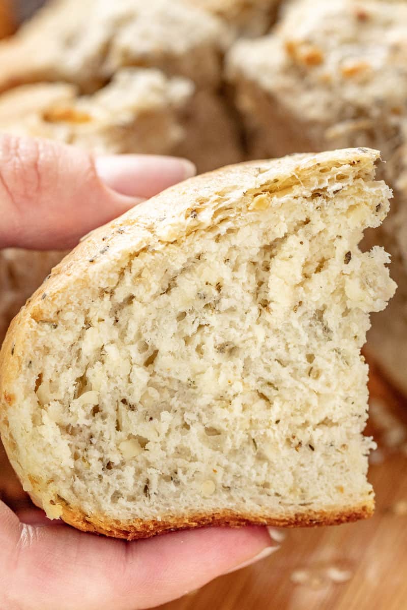 A loaf of rustic garlic parmesan herb bread cut in half.
