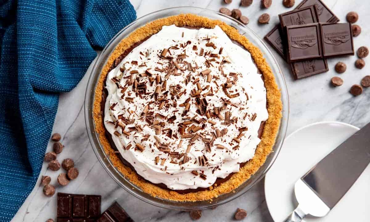 Bird's eye view of a chocolate cream pie surrounded by pieces of chocolate