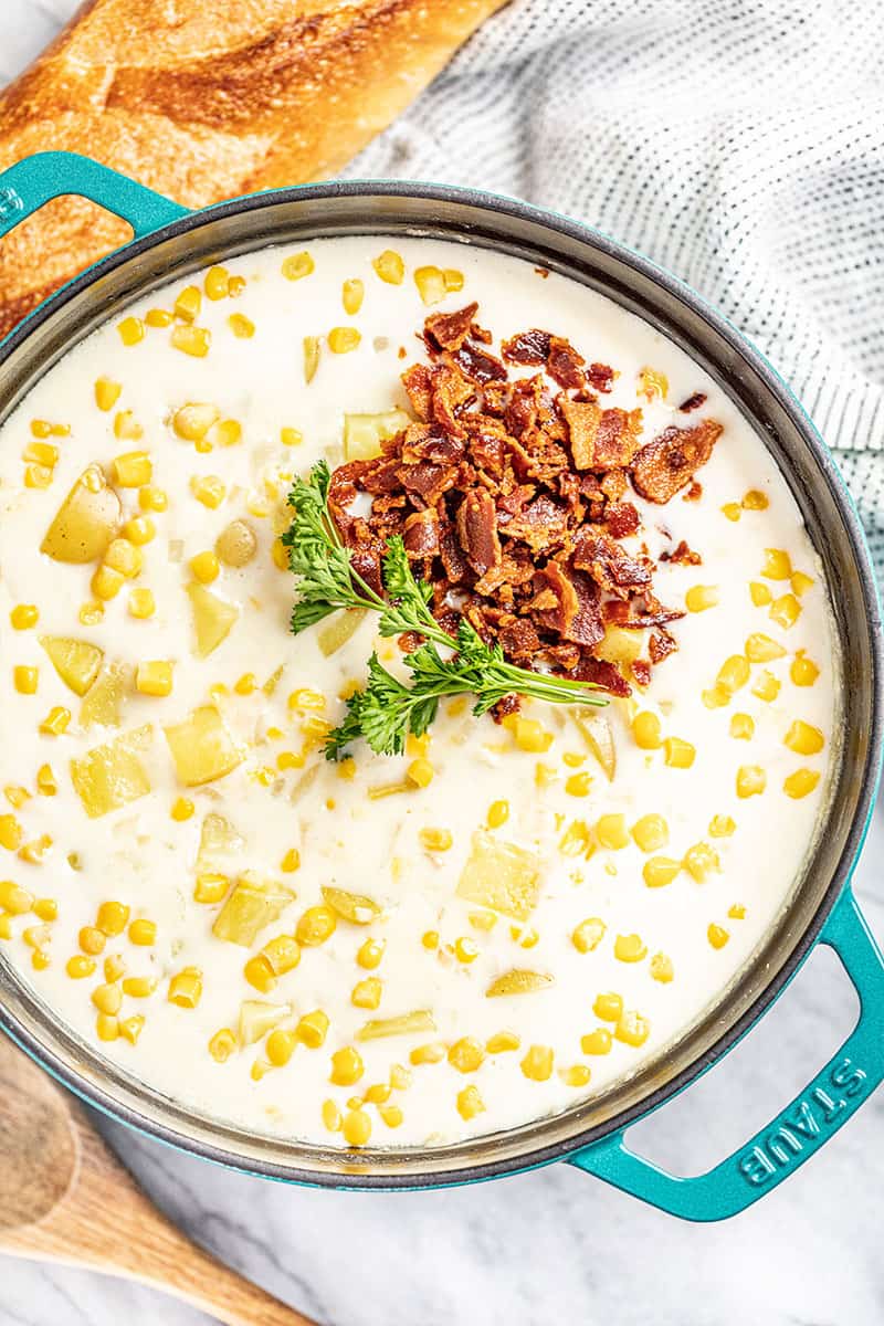 Corn Chowder in a pot topped with bacon.