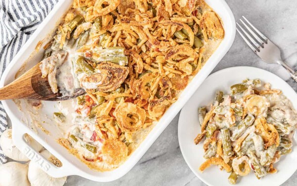 Bird's eye view of a serving of Green Bean Casserole with bacon and crunchy fried onion that has been scooped from the pan and placed on a serving plate