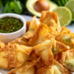 Cream Cheese Avocado Wontons on a plate with cilantro lime dipping sauce