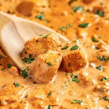 Butter chicken sauce with wooden spoon