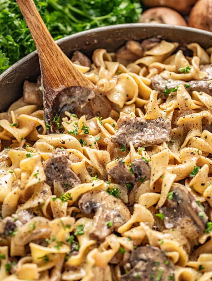 Beef stroganoff with wooden spoon and parsley in background
