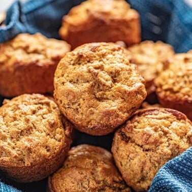 Bran muffins in a basket with a blue cloth underneath