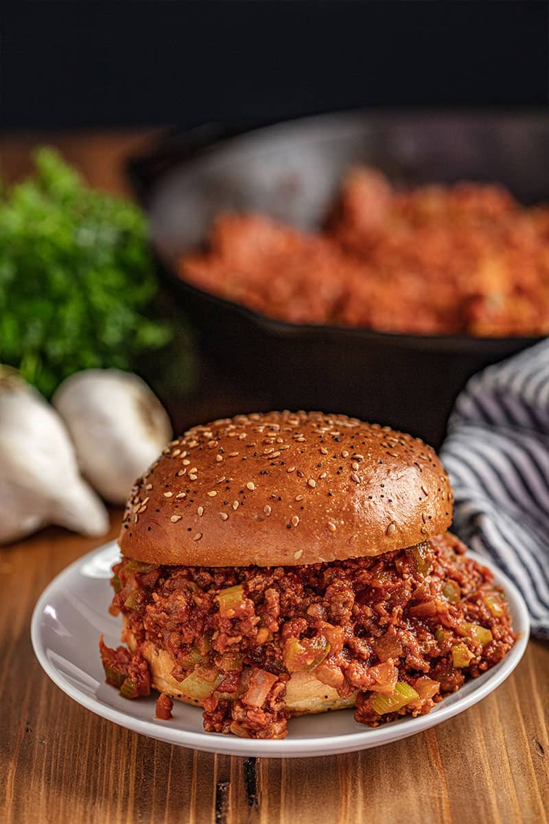 Sloppy Joe on white plate with skillet in background