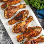 Cajun spiced chicken drumsticks lined up on a marble platter