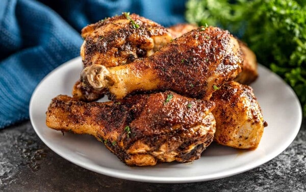Cajun Chicken Drumsticks piled up on a white plate