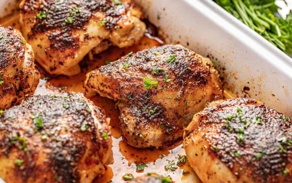 Crispy oven baked chicken thighs in white baking dish