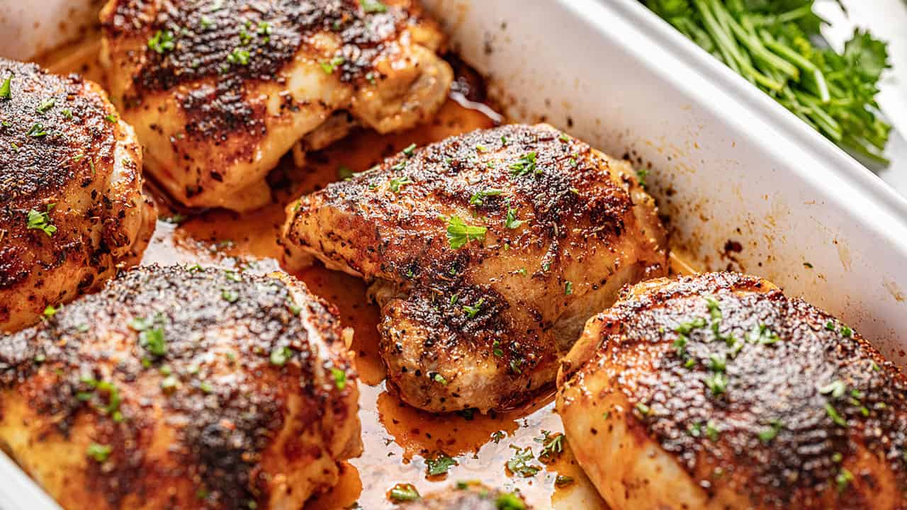 Crispy oven baked chicken thighs in white baking dish