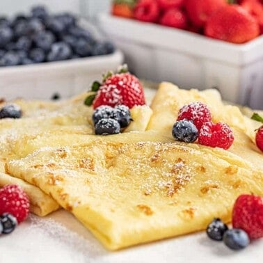 Easy crepes with strawberries and blueberries and powdered sugar on top