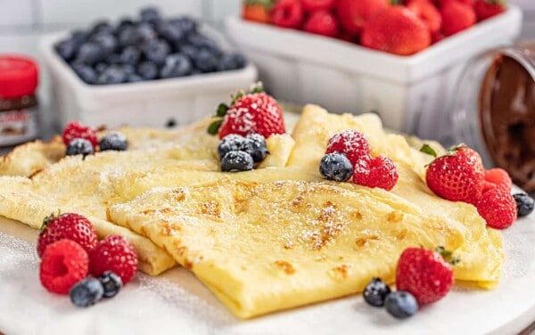 Easy crepes with strawberries and blueberries and powdered sugar on top