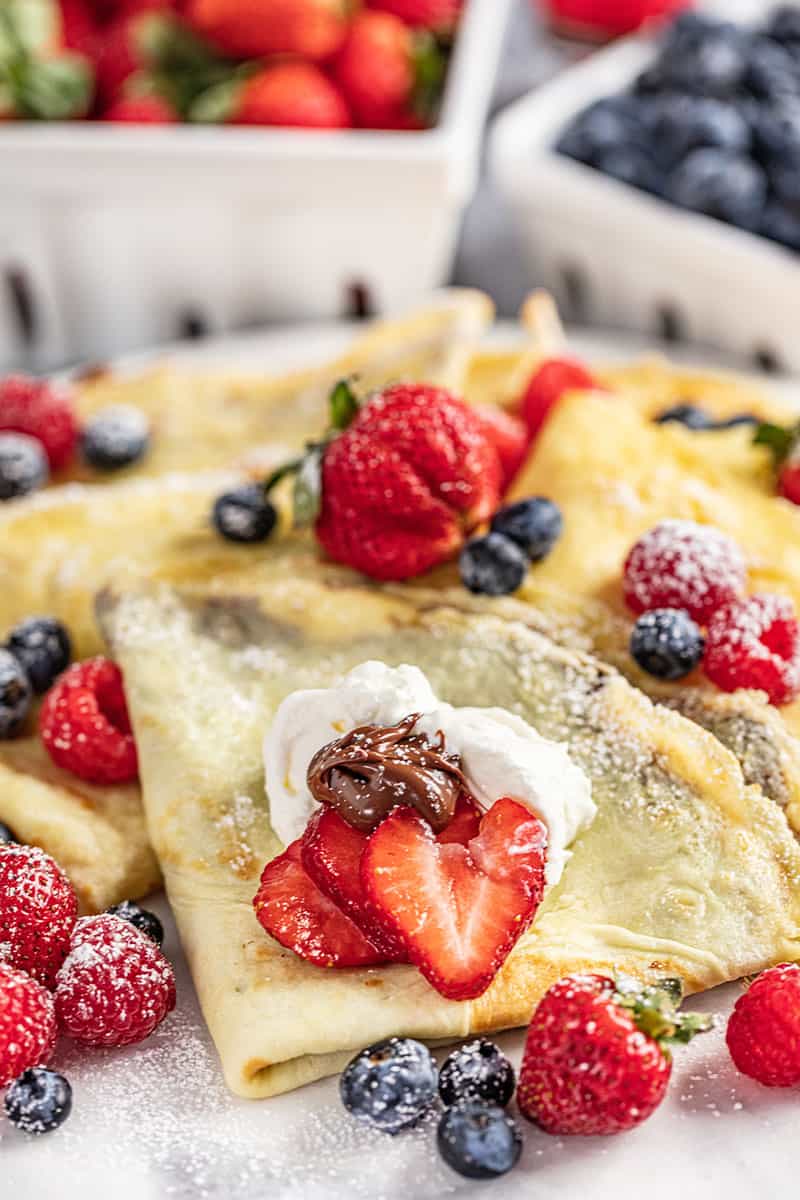 Easy crepes with strawberries and blueberries on plate.