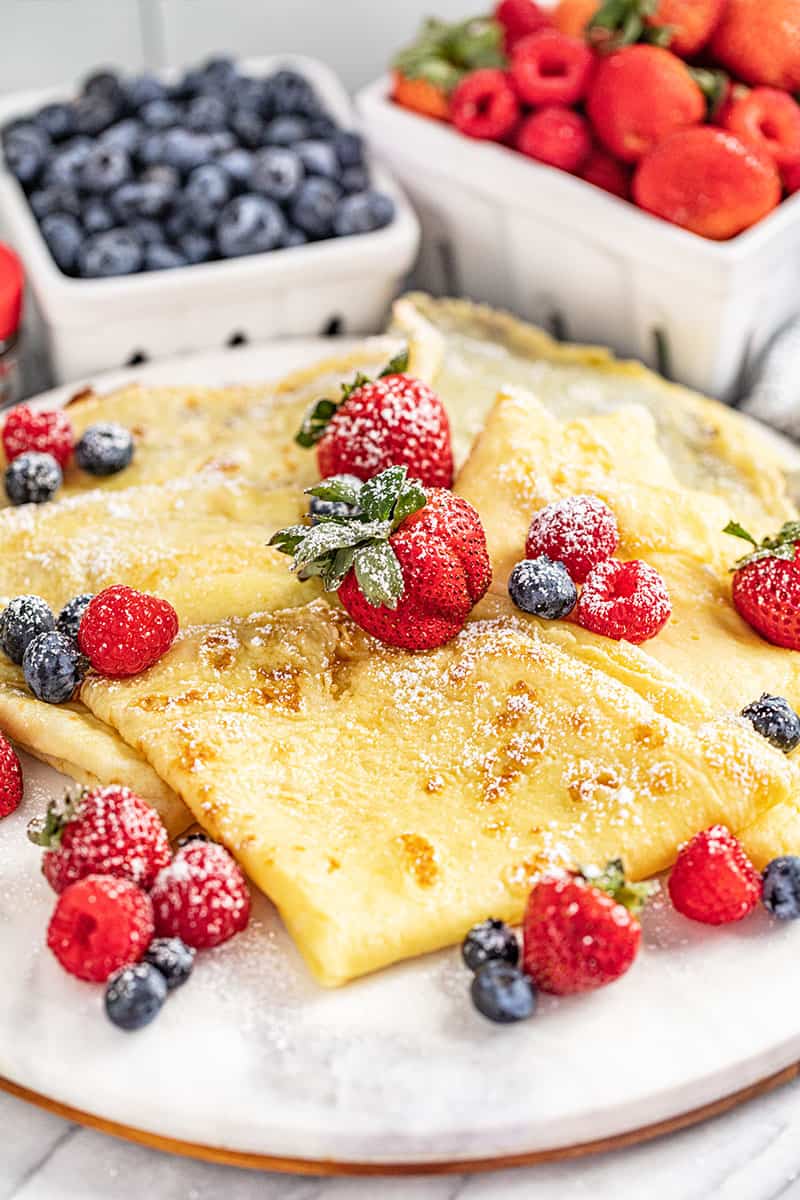 Easy crepes with strawberries and blueberries on plate.