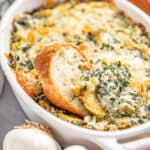 Bread dipped in spinach artichoke dip