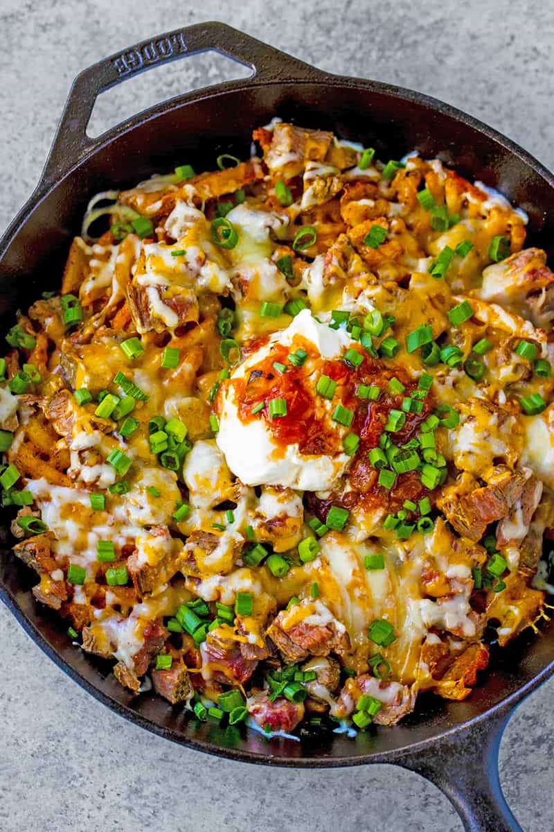 Bird's eye view of Close up of Steak and Potato Nachos in a skillet.