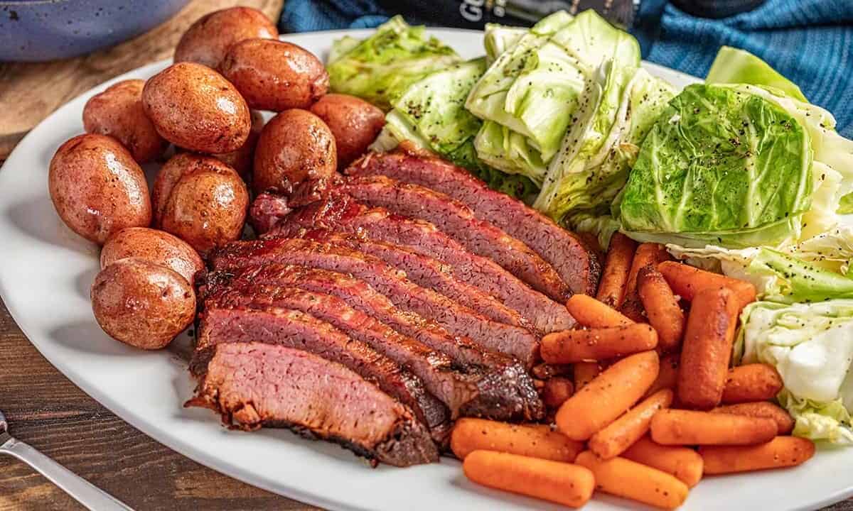 Corned beef and cabbage with carrots and potatoes on a platter.