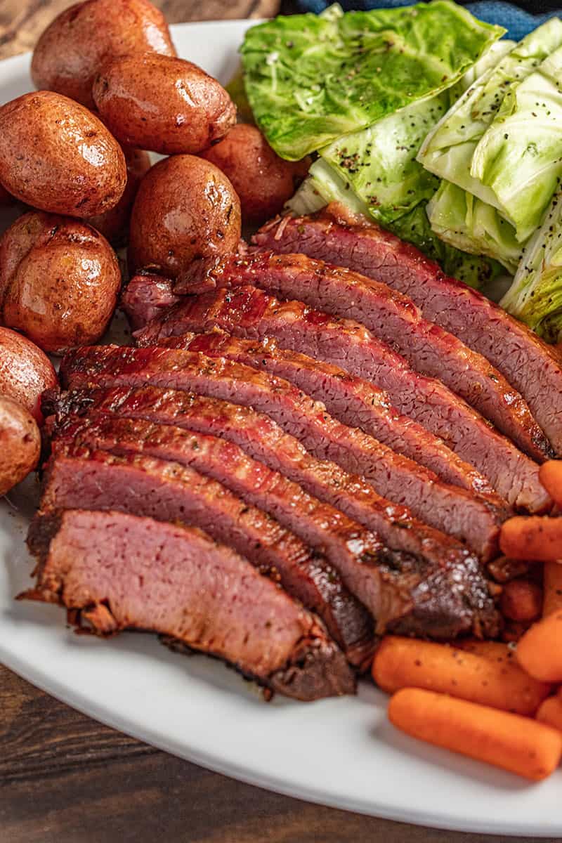 Sliced corned beef and cabbage with carrots and potatoes on a platter.