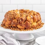 Gooey caramel pecan monkey bread on white cake plate.