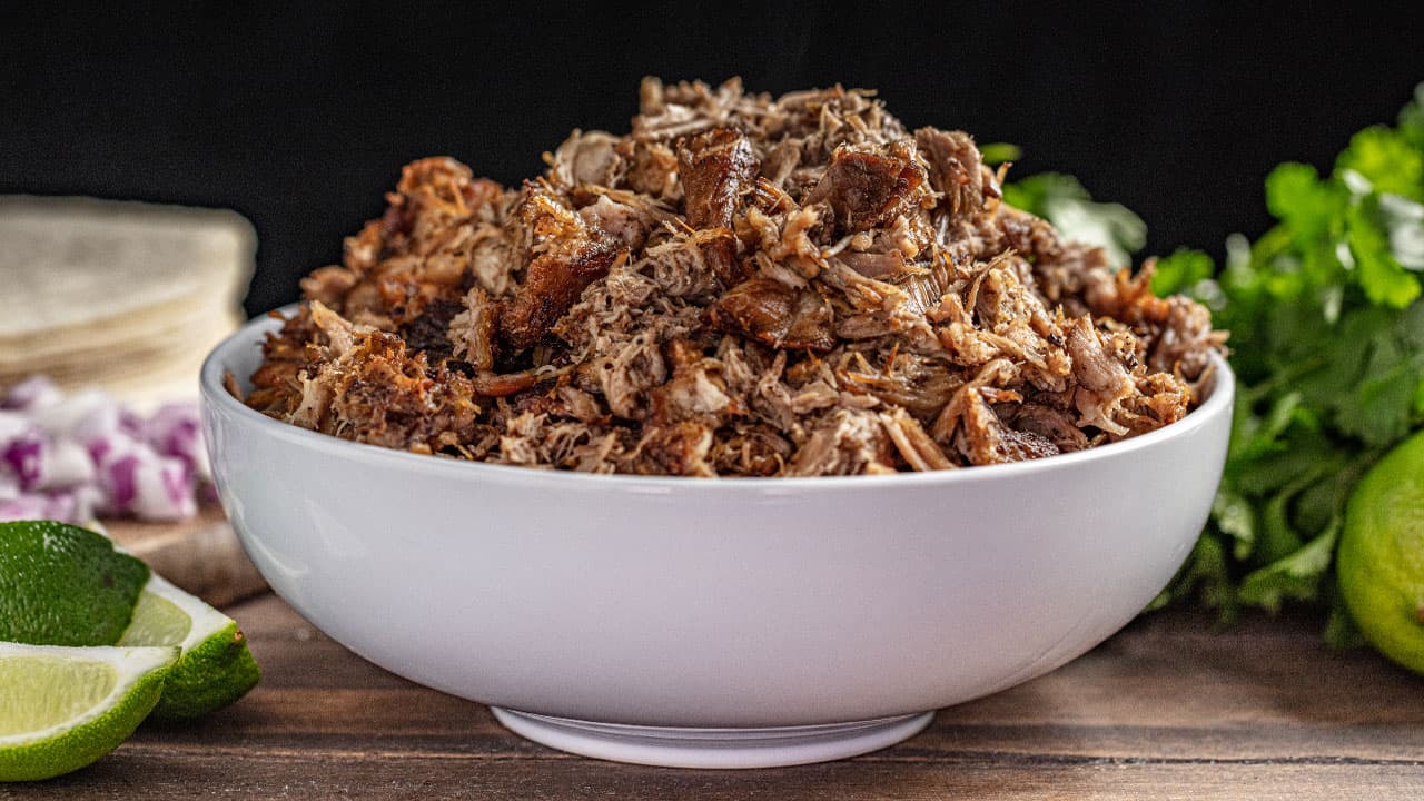 Crockpot carnitas in white bowl.