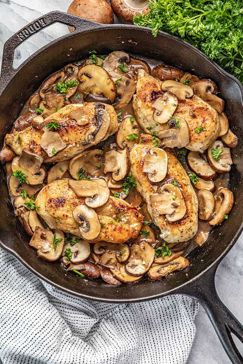 Chicken marsala with sliced mushrooms in a cast iron skillet