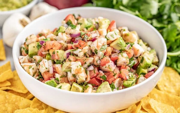 Shrimp ceviche in a white bowl surrounded by chips